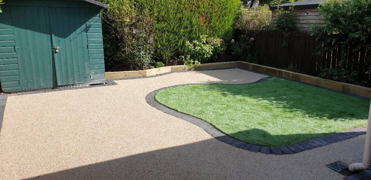 After photo of a New La Rochelle resin patio with artificial grass and curved block edging in Bridgwater by Quantock Paving