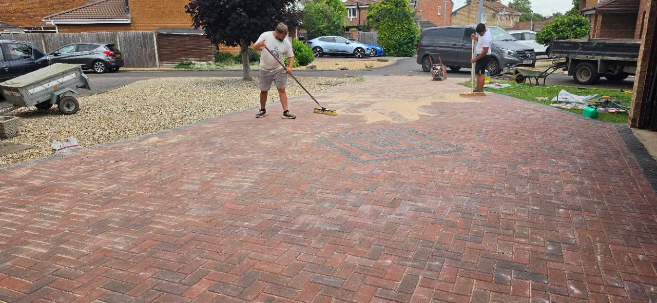 Jointing sand being brushed into Brett brindle block paving driveway in Bristol