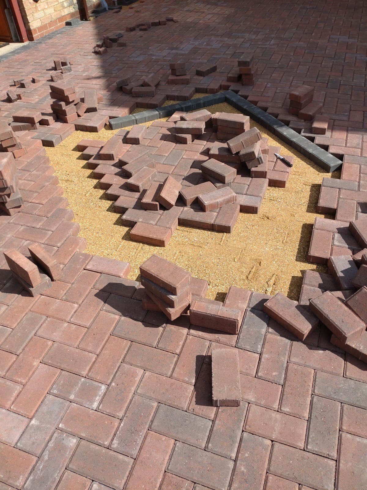 Brett brindle paviors being laid around a central diamond feature in Bristol
