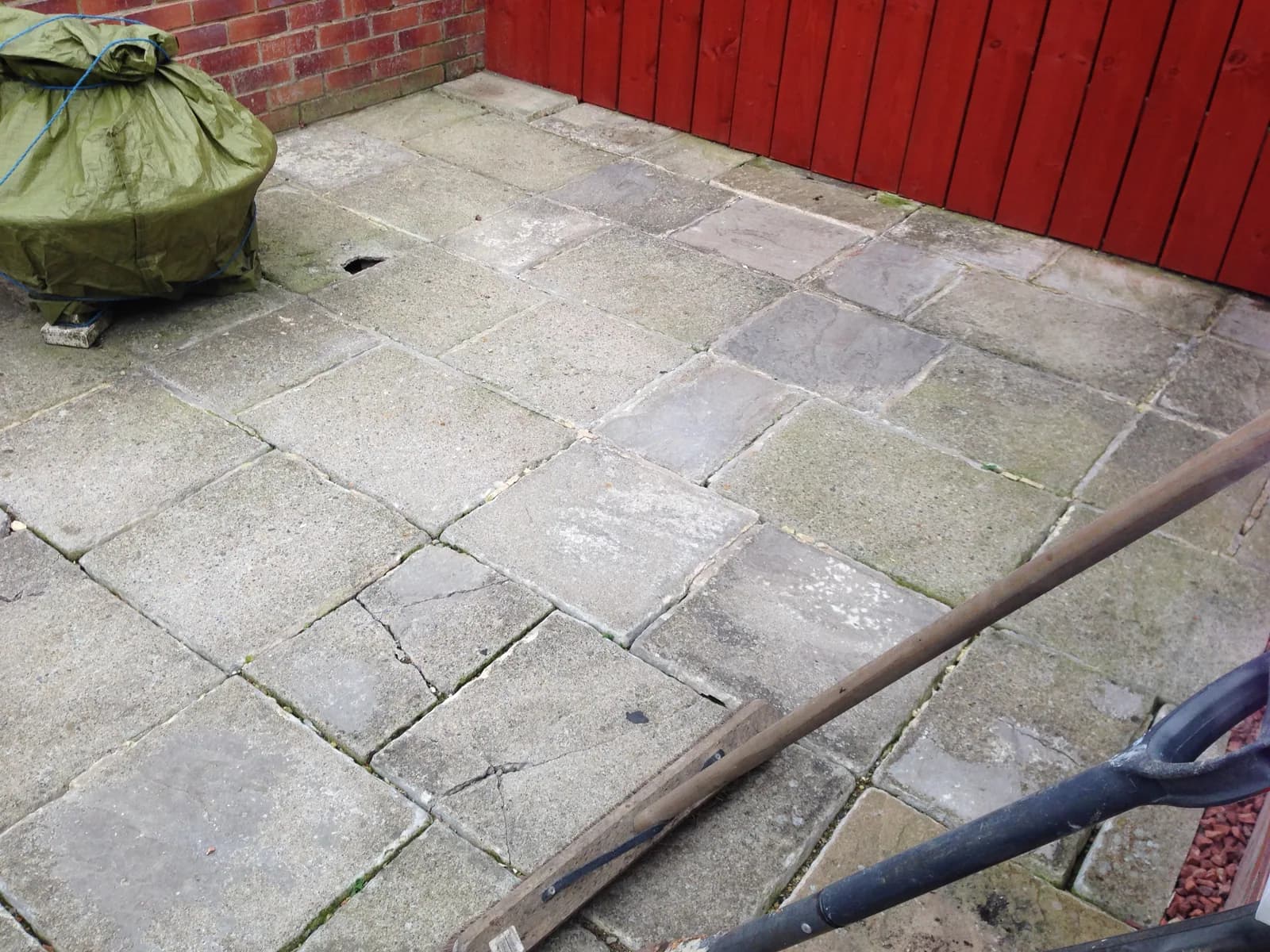 Tired patio paving beside the garden room before replacement in Burnham-on-Sea