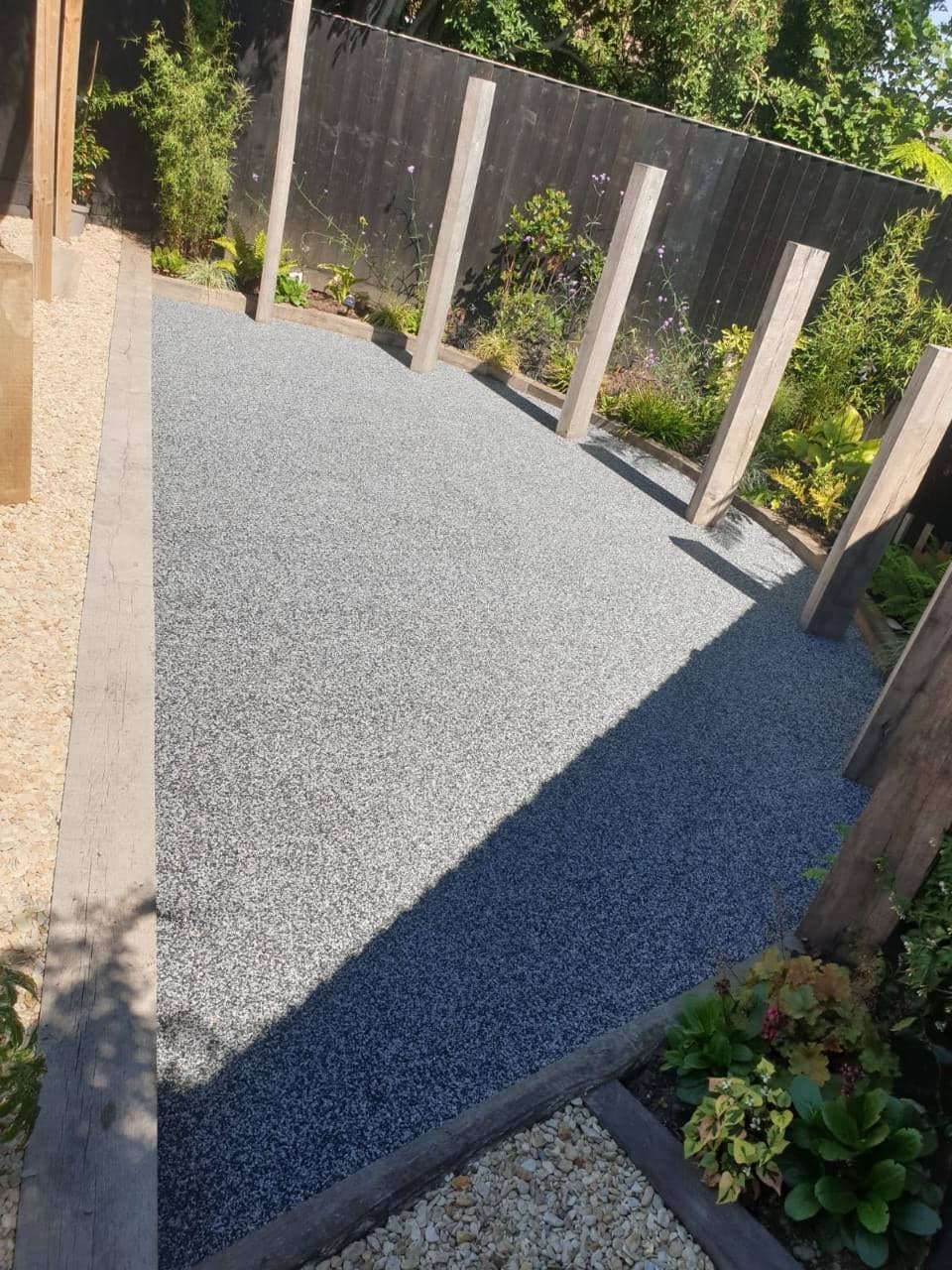 Finished New Palazzo resin bound patio in Burnham-on-Sea with planted borders and timber posts