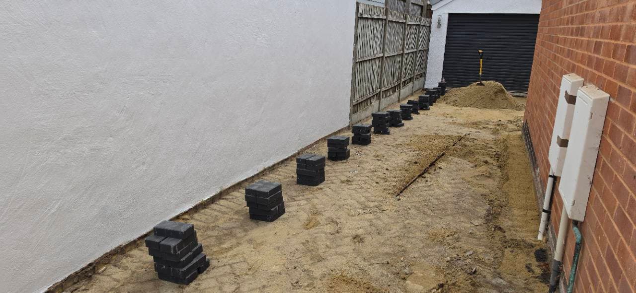Charcoal block paving border work set out along the Exminster side access