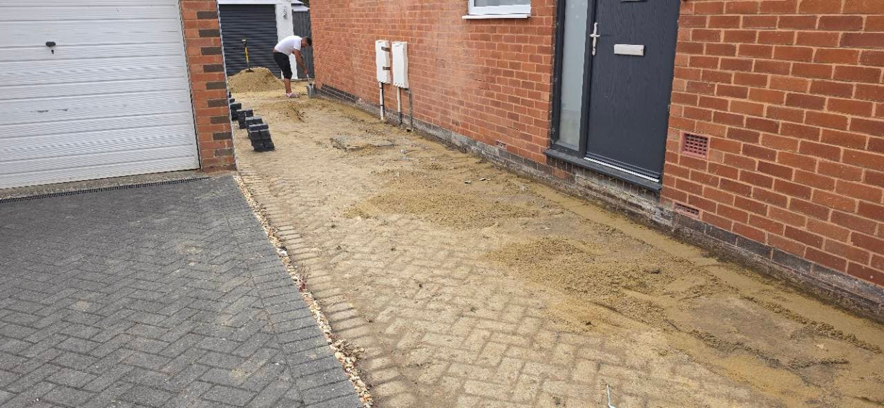 Charcoal block paving borders being set out along the Exminster side driveway