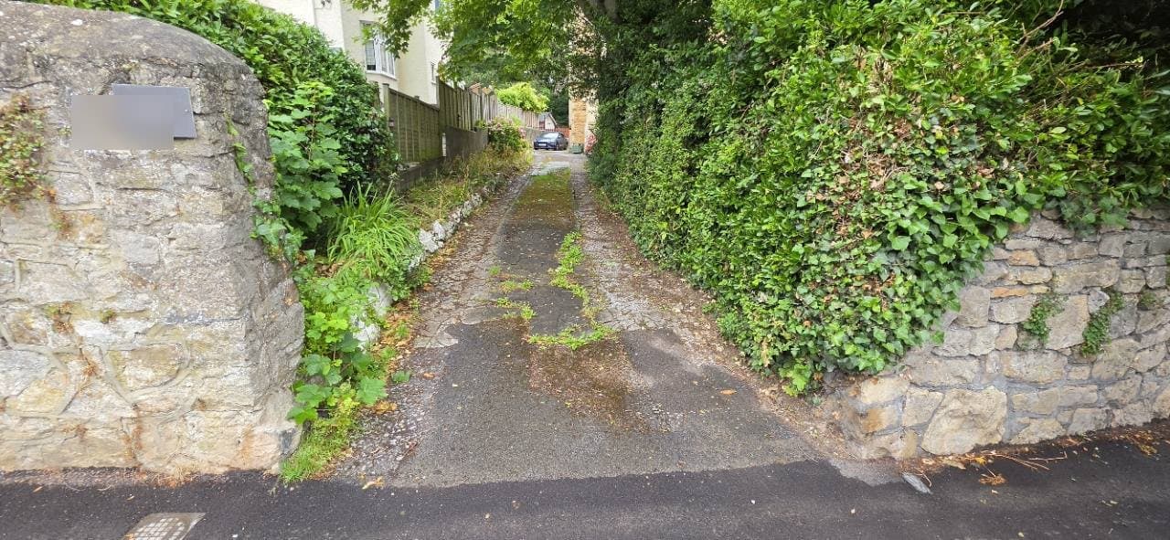 Worn tarmac entrance before the Weston-super-Mare resin driveway installation