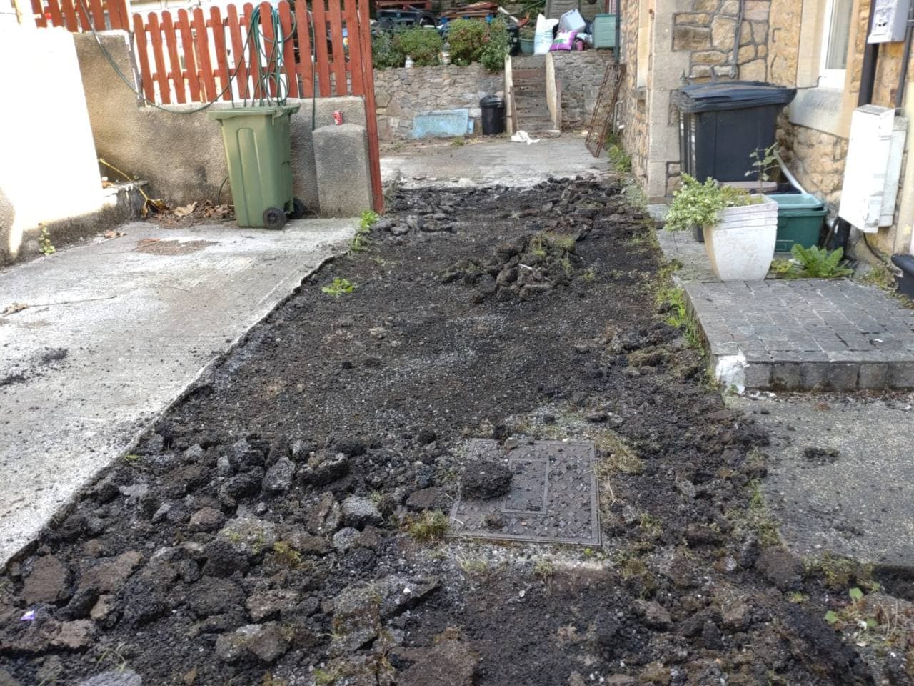 Failed surface removed around a service cover during driveway preparation