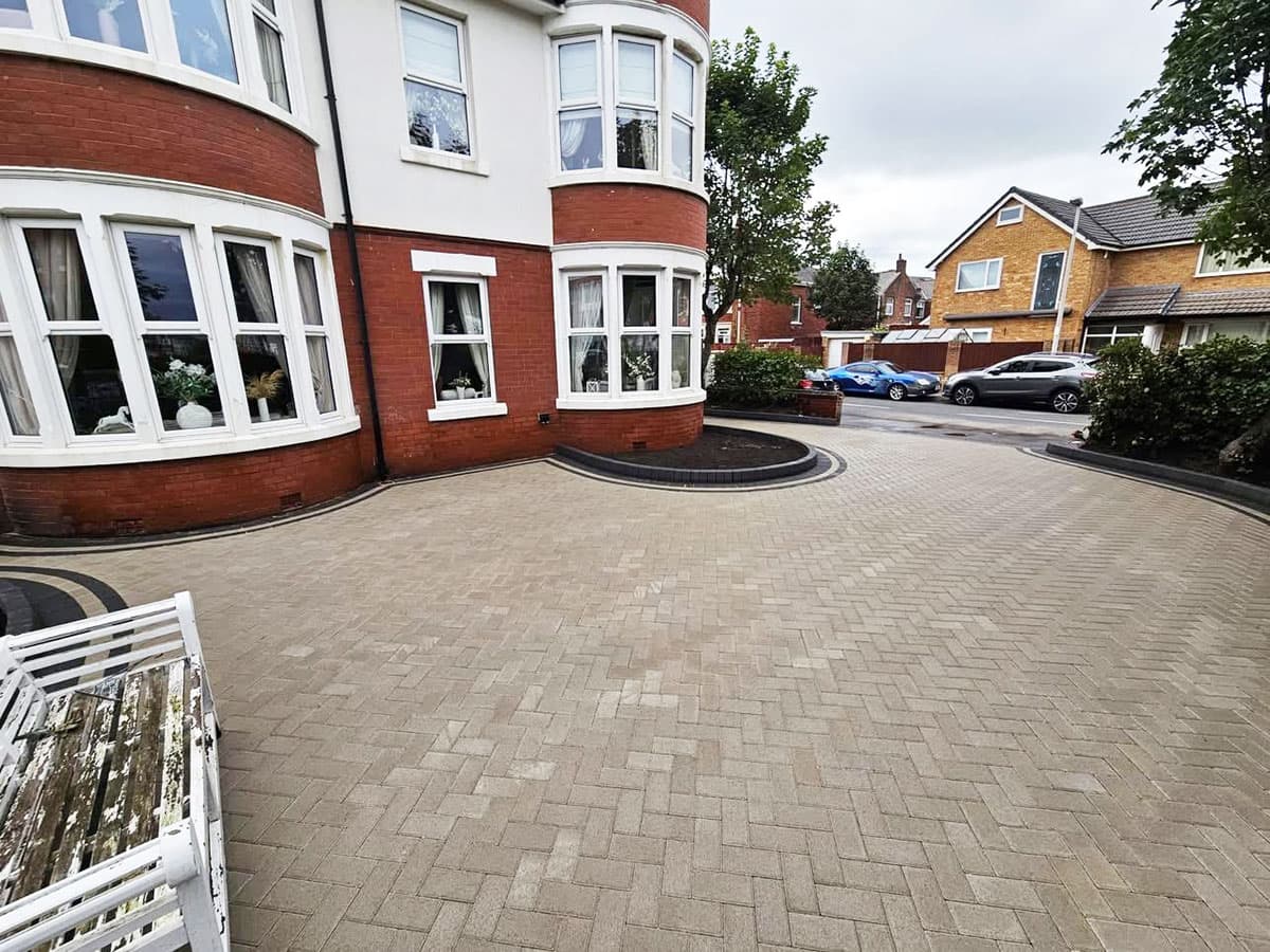 Cream block paved courtyard driveway with circular feature