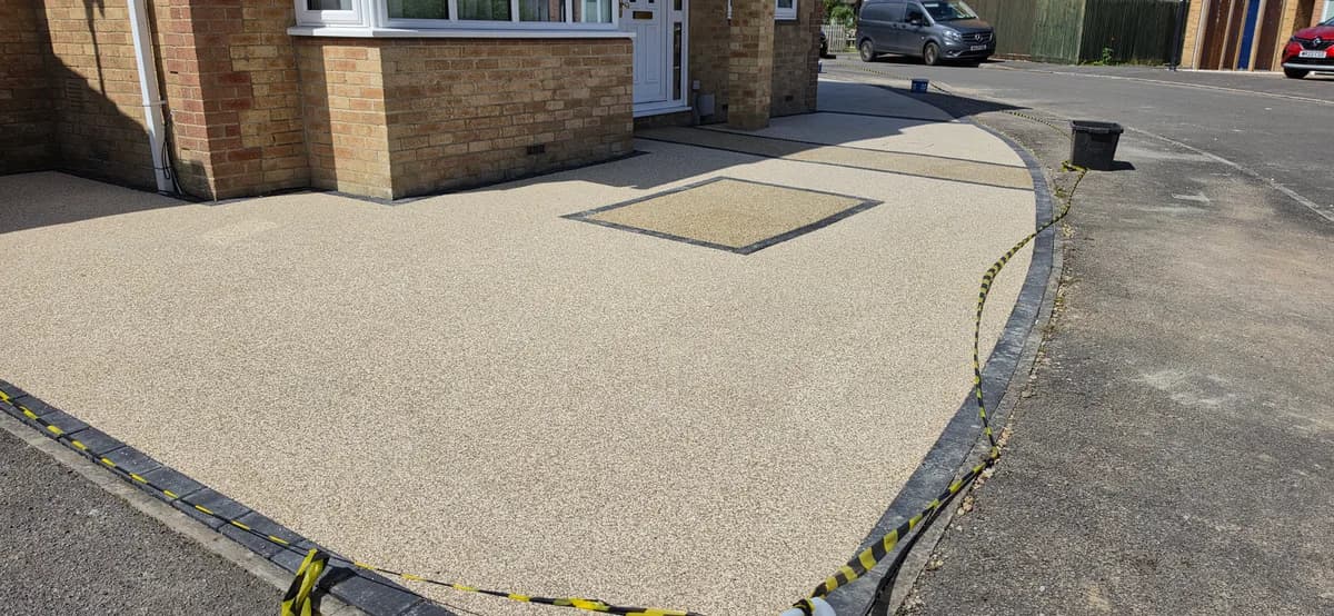 Beige resin bound driveway with contrasting resin inset and block paved edging